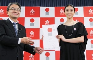 文化庁の宮田亮平長官(左)から「日本遺産大使」の任命証を手渡される武井咲さん=2016年12月14日午後、文科省
