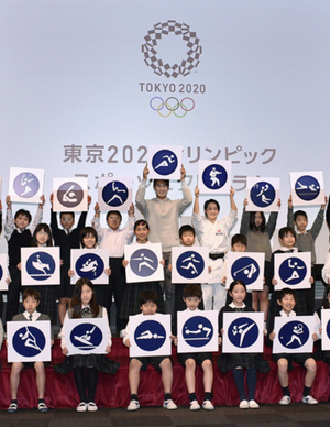 2020年東京五輪で使用される「ピクトグラム」を小学生と一緒に発表する陸上男子の飯塚翔太選手(上段中央)と空手女子の清水希容選手(その右隣)=2019年3月12日、東京都江東